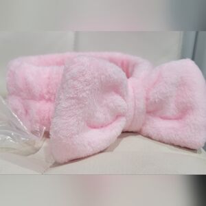 Soft microfiber pink spa headband with a bow detail.